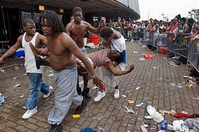 Four Hurricane Katrina survivors carry a man who collapsed